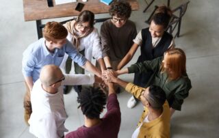 A team of real estate agents holding each other’s hands.
